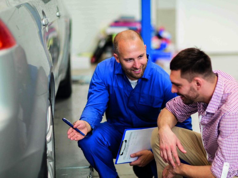 Mechaniker und Kunden besprechen Herstellergarantie beibehalten bei TOP Markenspezialist Autohaus Mommerskamp GmbH. Spezialist für Dacia